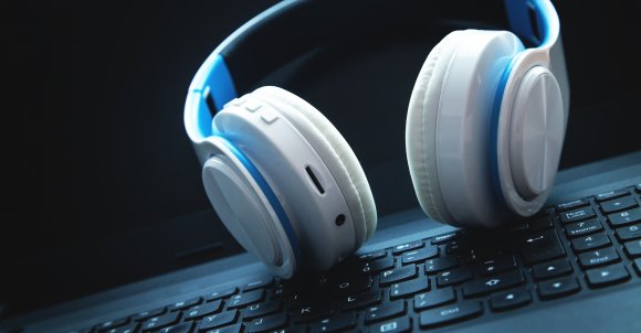 White headphones on laptop keyboard.